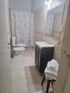 a bathroom with a sink and a toilet and a mirror at Casa Microcentro- luminoso- silencioso in Pergamino