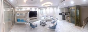 a large living room with blue chairs and a tv at The Park Residence - ذا بارك ريزدنس in Cairo