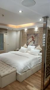 a bedroom with a large white bed in a room at The Park Residence - ذا بارك ريزدنس in Cairo