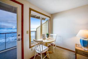 a room with a table and chairs and a window at Beachy View at Rock Creek Inn in Rockaway Beach