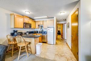 a kitchen with wooden cabinets and a white refrigerator at Beachy View at Rock Creek Inn in Rockaway Beach
