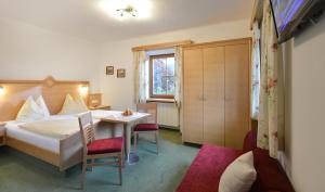 a bedroom with a bed and a table and chairs at Schneeberghof in Westendorf