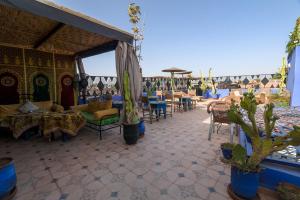 um pátio com cadeiras, mesas e cactos em Riad Salma Restaurant Spa em Marraquexe