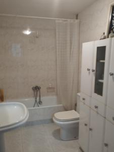 a bathroom with a toilet and a tub and a sink at Rincón de descanso in Ponferrada