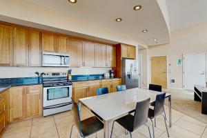 a kitchen with a white table and chairs at The Oceanfront Estate #204 in Rockaway Beach