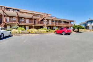 a red car parked in a parking lot in front of a building at Pacific Sands Unit #10 in Neskowin