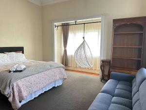a bedroom with a bed and a couch and a window at Parnell City Haven Same Price for 1 to 6 Guests Villa with Full Kitchen in Auckland