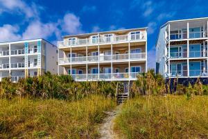 un edificio en la cima de una colina con césped en Seaside Condo 301, en Folly Beach