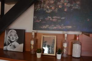a shelf with bottles and a picture of a woman at Residence con Piscina Vista Monte Nerone in Piobbico