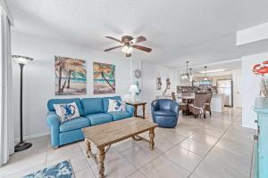 a living room with a blue couch and a ceiling fan at Buena Vista Unit 305 in Gulf Shores +33 photos