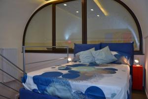 ein Schlafzimmer mit einem Bett mit blauen Kissen in der Unterkunft San Biagio, 25 Apartment A in Neapel