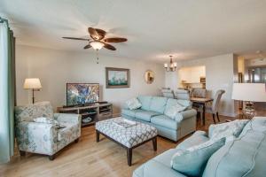 a living room with blue furniture and a ceiling fan at Turn Of River 2F in Folly Beach