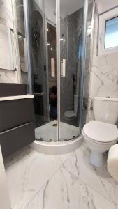 a white bathroom with a shower and a toilet at Domki SILVER 3 in Jarosławiec +13 photos