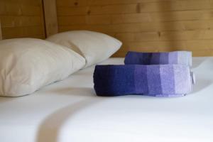 a purple pillow sitting on a bed with two pillows at Super cute Treehouse by the river in Mostar