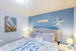 a bedroom with a bed with a blue wall at On The Sand in Rockaway Beach
