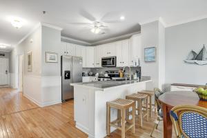 a kitchen with white cabinets and a table and chairs at Marsh Winds 2K in Folly Beach