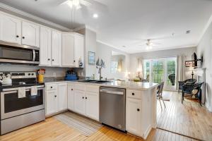 a kitchen with white cabinets and stainless steel appliances at Marsh Winds 2K in Folly Beach +15 photos
