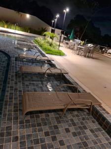 a row of benches on a sidewalk at night at Golden Sunset com vista mar - Icaraí in Niterói