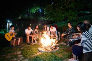 a group of people sitting around a fire at Kanach Tun Boutique Hotel in Yenokavan