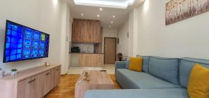 a living room with a blue couch and a table at A few minutes from Siggrou Street in Athens