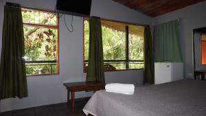 Postel nebo postele na pokoji v ubytování Manakin Lodge, Monteverde