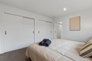 - une chambre avec des murs blancs et un grand lit dans l'établissement Lake McKay Escape, à Wanaka