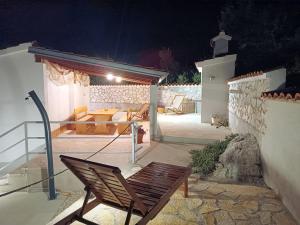 a wooden chair sitting on a patio at night at House Inga in Pirovac