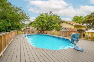 a swimming pool on a wooden deck with a chair at Whelks On Willow in Chincoteague