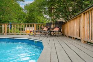a deck with a table and chairs next to a pool at Whelks On Willow in Chincoteague