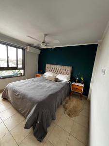 ein Schlafzimmer mit einem großen Bett und einer grünen Wand in der Unterkunft Temporario San Martin in Esperanza