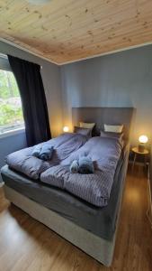 a bedroom with a large bed with two pillows on it at Seaside cabin with stunning view! in Ålesund