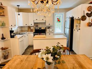 a kitchen with a table and a dining room at Chalet -Havre au bord de l'eau in Chertsey