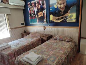 ein Hotelzimmer mit 2 Betten und einem Filmplakat in der Unterkunft El rancho e Matias in Villa Lía