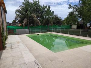 ein Pool in einem Garten mit einem Zaun in der Unterkunft El rancho e Matias in Villa Lía