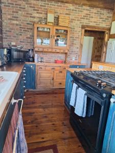 a kitchen with a black stove and wooden floors at Breathtaking Cabin Away From Reality in Clark +19 photos