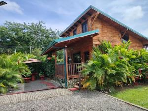 a wooden house with a porch and some trees at Cabaña la Corteza in Tanque