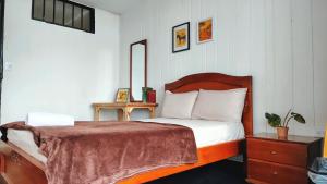 a bedroom with a bed with a wooden head board at La Chiva Hostal Armenia in Armenia +21 photos