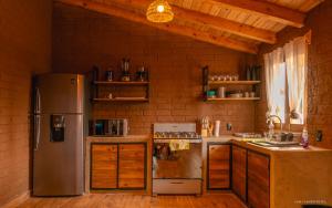 a kitchen with a stainless steel refrigerator and wooden cabinets at Cabaña el Durazno in Tapalpa