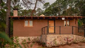 a small brick house with a porch and a balcony at Cabaña el Durazno in Tapalpa