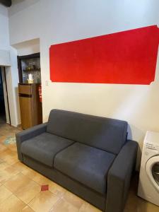a couch in a living room with a painting on the wall at Verderame - Apartment in Licusati