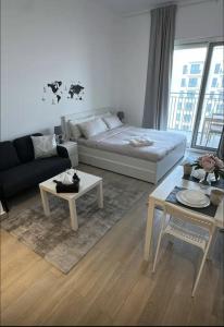 a living room with a couch and a table at F1 - Lily Studio Waters Edge Yas Island Theme Parks, Canal and Pool View in Abu Dhabi