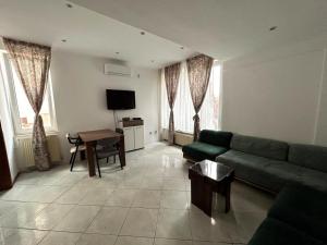 a living room with a green couch and a table at Peaceful apartment with yard and parking in Skopje