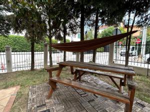 a hammock sitting on top of a wooden bench at Peaceful apartment with yard and parking in Skopje