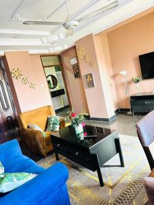 a living room with a couch and a table at Elegant & Modern 3-Bedroom Apartment Central Downtown Escape in Dar es Salaam