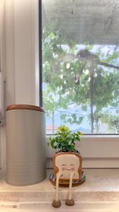 a plant sitting on a window sill next to a flower pot at Apartman Minja 2 Trebinje in Trebinje +20 photos