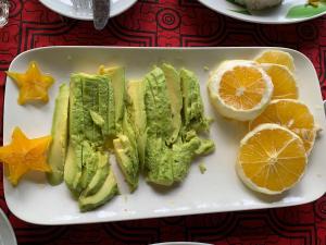 a plate of food with avocado and oranges on a table at Oropendola Expeditions in Tambopata