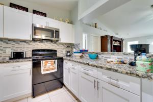 a kitchen with white cabinets and stainless steel appliances at Fenced Yard and Game Room Family Home in Kissimmee! in Kissimmee +16 photos