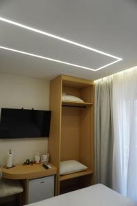 a room with a bed and a desk and a tv at Ionian Blue Apartament 5 in Himare