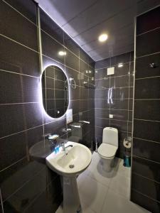 a bathroom with a sink and a toilet and a mirror at Hotel Tiflis Town in Tbilisi City