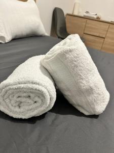 a white towel is laying on a bed at Studio Bethel cosy à Villejuif centre Paris in Villejuif